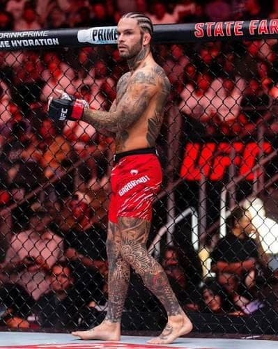 Cody Garbrandt moving along the cage in red fight shorts