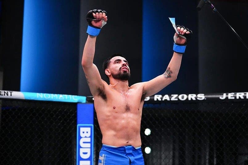 Joseph “Bo Po” Morales with both arms raised in the cage after a win