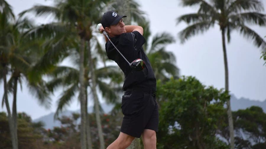 Riley Bell holding a follow-through on a palm-lined course