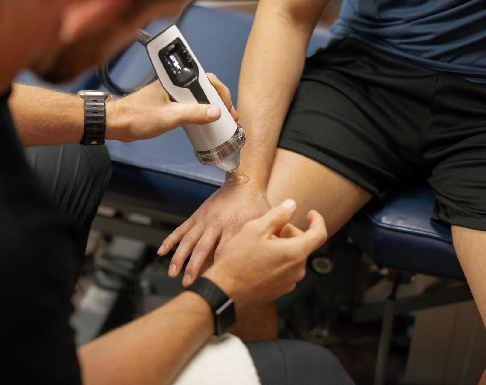 Focused shockwave therapy being applied along a patient's forearm