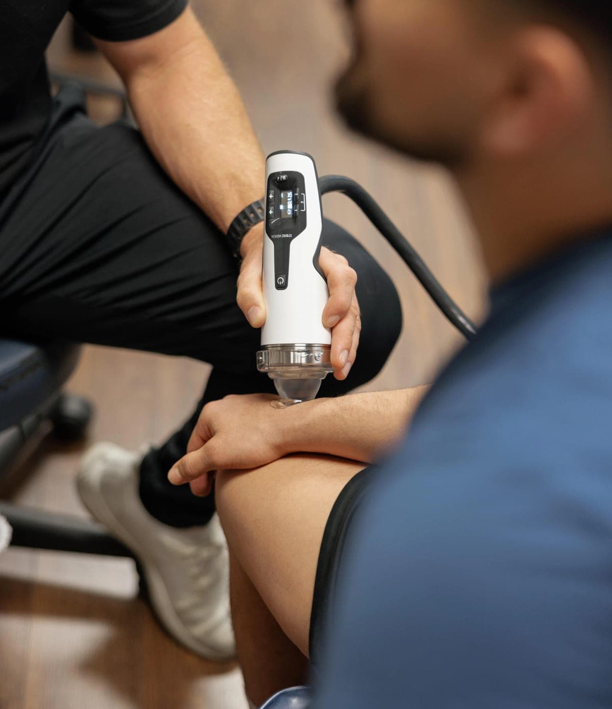 Focused shockwave therapy being applied to a patient's knee