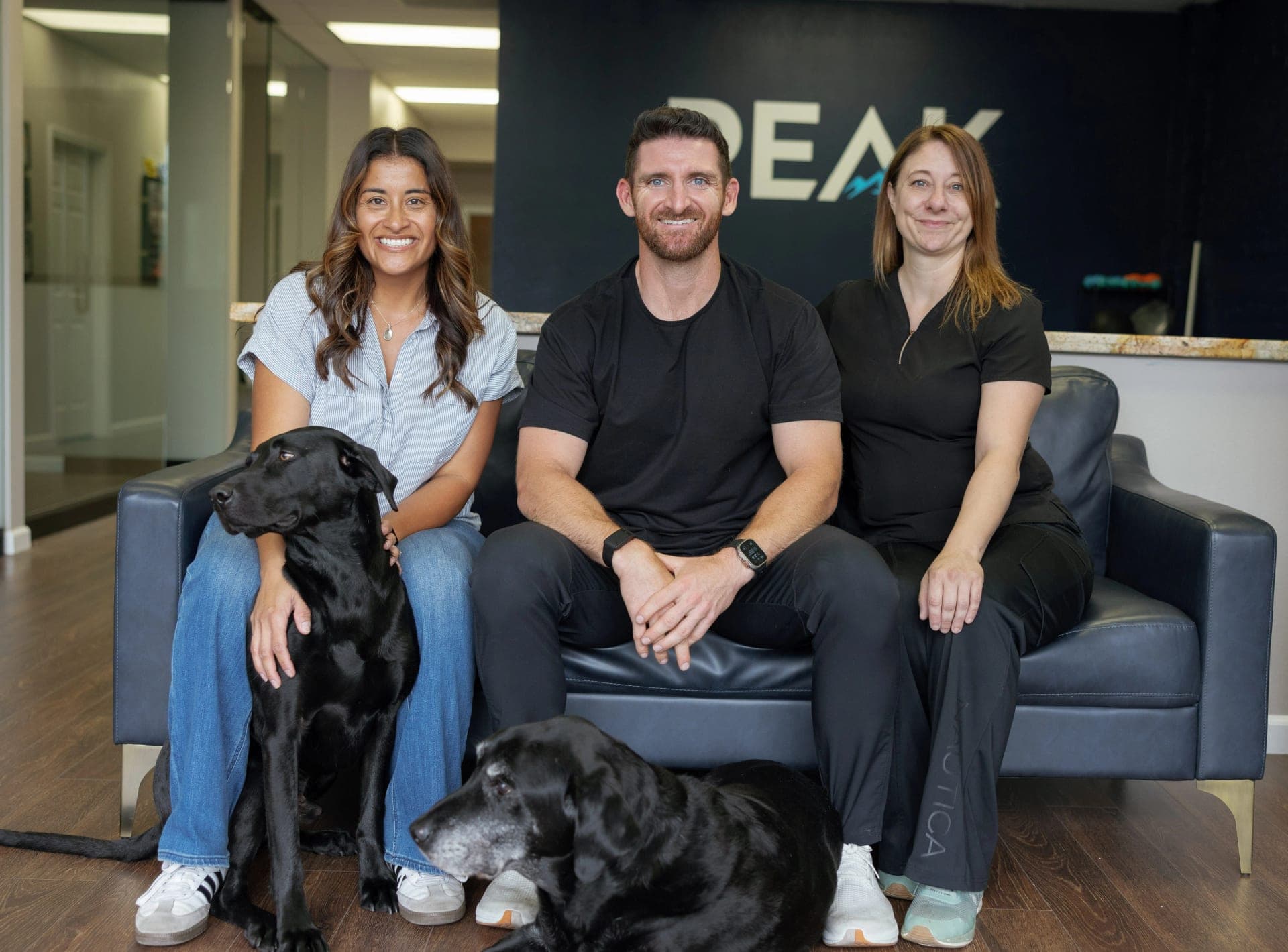 The Peak team in the clinic reception with Eli and Dexter, Dr. Brennan's two dogs